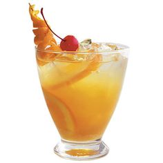 a glass filled with orange juice and topped with a cherries garnish on the rim