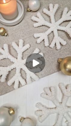 snowflakes and ornaments on a table with candles