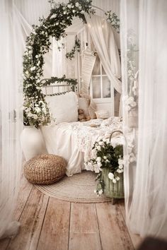 a bedroom with white curtains and flowers on the bed