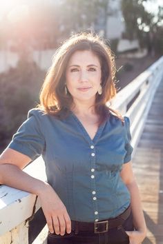 a woman standing on a bridge with her hands on her hips