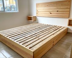 a bed frame made out of wooden slats in a room with tile flooring