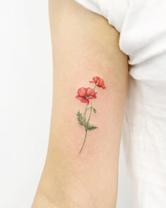 a small red flower on the left side of the arm, with green stems and leaves