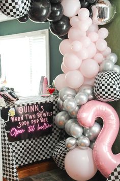 balloons and decorations are displayed in the corner of a room with a checkered wall