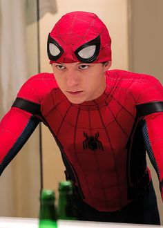 a young man dressed as spider - man in front of a mirror