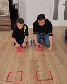 a man and boy are playing with their toys on the floor in front of them