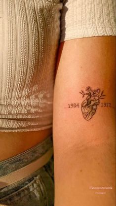 two women with tattoos on their arms, one has a heart and the other has an arrow