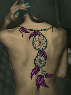 the back of a woman's body with a tattoo on her upper and lower back