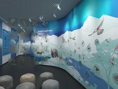 an exhibit room with many animals on the wall and rocks in the floor, along with benches