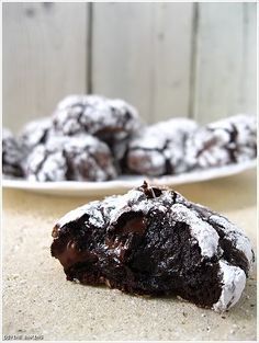 chocolate crinkle cookies sitting on top of a white plate next to another plate