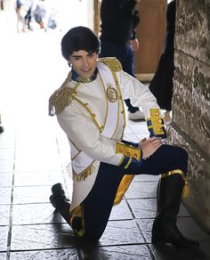 a man dressed in an elvis costume sitting on the ground