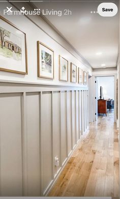 a long hallway with pictures on the wall and wood flooring in front of it