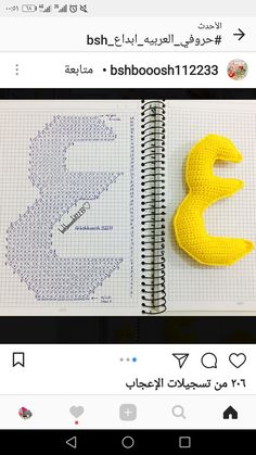 a yellow object sitting on top of a notebook next to a spiral bound book with arabic writing