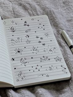 an open notebook with stars and moon drawings on it