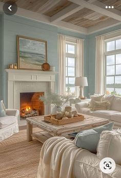 a living room filled with furniture and a fire place in front of two windows on either side of the fireplace