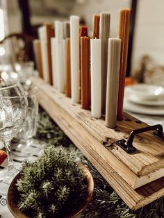 a wooden shelf with candles and wine glasses on it