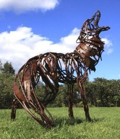 a large metal horse standing in the middle of a field