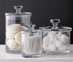 three glass containers filled with marshmallows on top of a counter