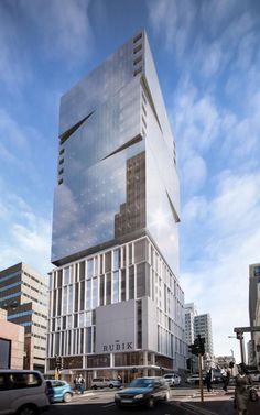 a very tall building sitting on the side of a road next to some cars and buildings