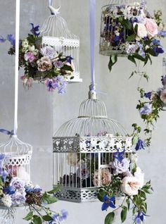 a birdcage filled with lots of flowers on top of a table