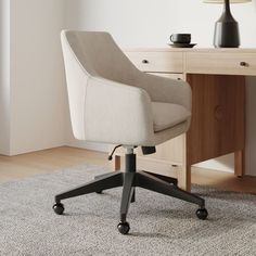 an office chair sitting on top of a rug next to a desk with a lamp