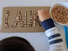 a child is making letters out of cereal