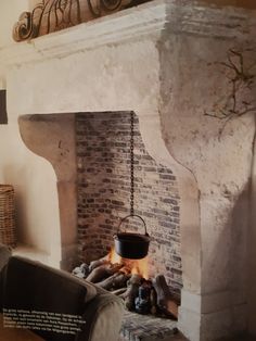 a fireplace with a pot hanging from it's side