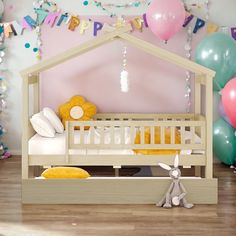 a baby's room with balloons and decorations on the wall, including a crib