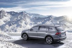 the new volkswagen tigua is parked in front of snowy mountains and snow - capped peaks