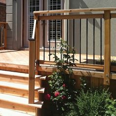 a wooden deck with railing and flowers on it