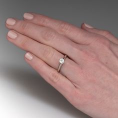 a woman's hand with a diamond ring on it