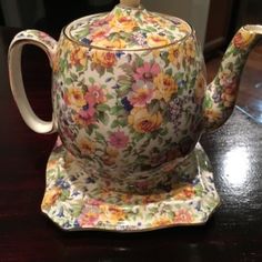 a tea pot and saucer sitting on a table