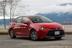 a red car is parked on the side of the road