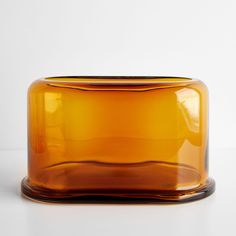 a brown glass vase sitting on top of a white table