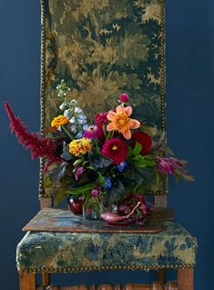 a vase filled with flowers sitting on top of a wooden chair