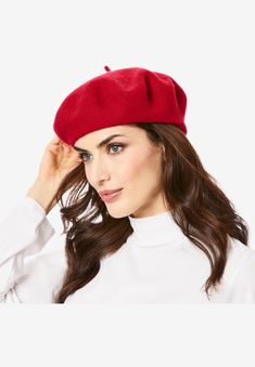 a woman is wearing a red hat and white shirt, she has her hand on her head