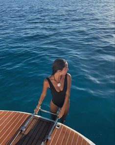 a woman sitting on top of a boat in the water