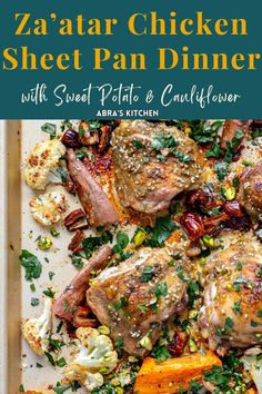 a sheet pan filled with meat and vegetables on top of a wooden table next to a white