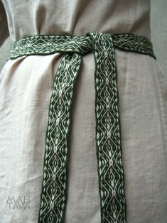 the back of a woman's dress with a green and white belt