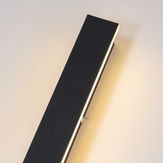 a close up of a black object on a white surface with light coming from it