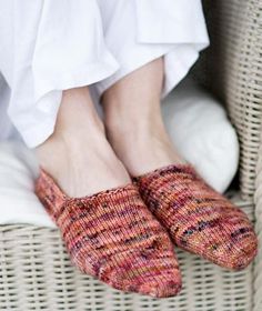 a person wearing slippers sitting in a wicker chair