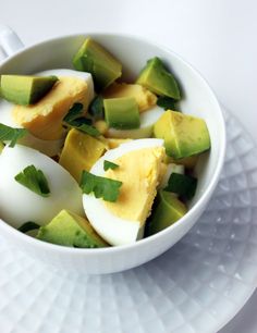 an egg and avocado salad in a white bowl