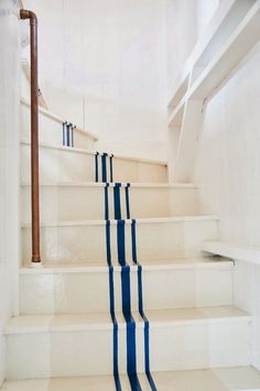 a set of stairs with blue and white striped carpeting on the risers in an empty room