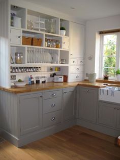 a kitchen with gray cabinets and wooden floors