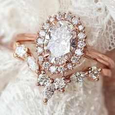 a close up view of a ring with diamonds on the band and an oval shaped diamond in the middle