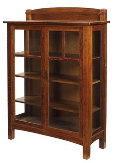 an oak bookcase with glass doors and shelves on the front, is shown against a white background