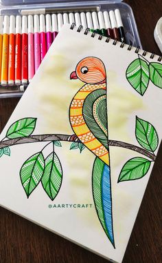 a drawing of a bird on a tree branch next to colored crayon pencils