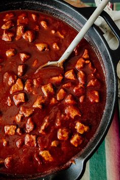 a pot filled with meat and sauce on top of a table