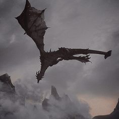 a dragon flying in the sky over some mountains