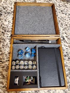 an open wooden box with dice and other items in it