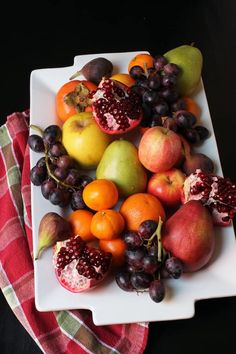 a white plate topped with fruit on top of a table